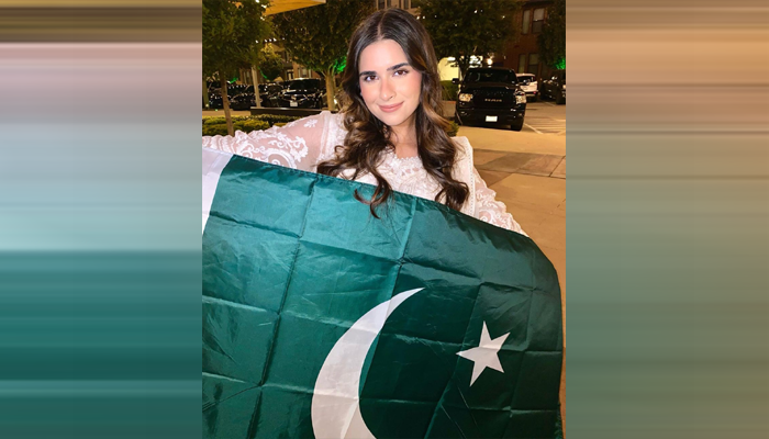 Sabeen proudly raising the Pakistani flag at the Miss Global International Competition
